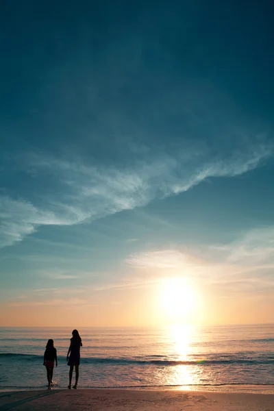 Dwie dziewczyny na plaży podczas zachodu słońca. — Zdjęcie stockowe