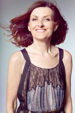 Kıvırcık saçlı mutlu orta yaşlı kadın.