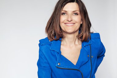 Mavi ceketli mutlu orta yaşlı kadın.