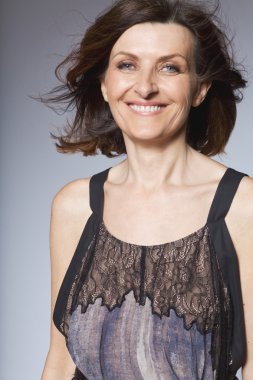 Uzun elbiseli mutlu orta yaşlı kadın.