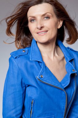 Mavi ceketli mutlu orta yaşlı kadın.