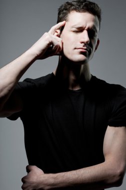Siyah t-shirt gri arka plan üzerinde poz içinde adam.