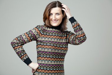 Gri arka plan üzerinde poz mutlu olgun kadın.