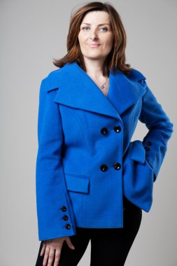 Gri arka plan üzerinde poz mutlu olgun kadın.