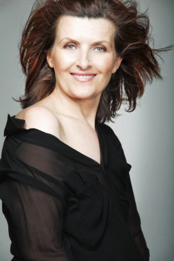 Siyah elbiseli mutlu orta yaşlı kadın.