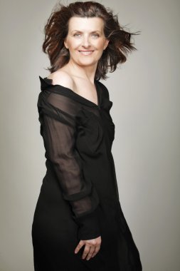 Siyah elbiseli mutlu orta yaşlı kadın.