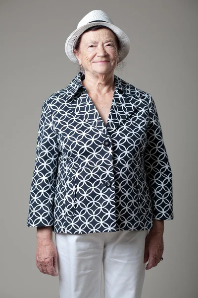 Seniorin posiert auf grauem Hintergrund. — Stockfoto