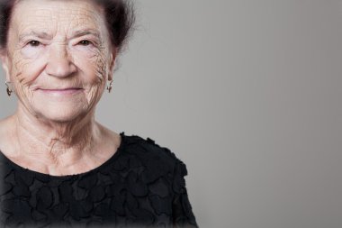 Üst düzey Bayan gri arka plan üzerinde poz.