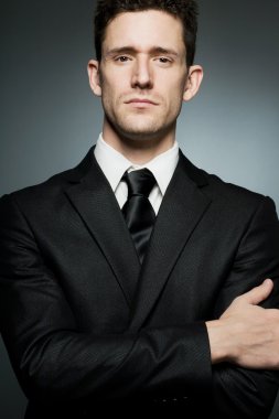 Güven ifade siyah elbiseli genç işadamı.