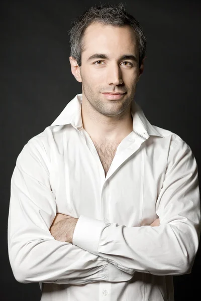 Bonito homem posando em camisa branca no fundo escuro . — Fotografia de Stock