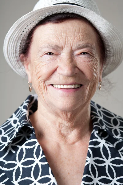 Seniorin posiert auf grauem Hintergrund. — Stockfoto