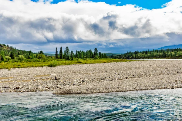 Bir yaz günü kayaların arasında akan berrak bir kuzey nehri.