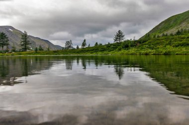 Bulutlu bir günde Kutup altı Urallar 'ın dağlarında soğuk bir göl.