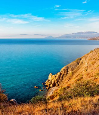 Güneşli bir yaz sabahında kayaların arasında güzel bir deniz koyuyla manzara
