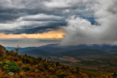 Gün batımında dağlardan tepelerin üzerinden ve Kırım 'da bir sonbahar akşamında denizi izle.