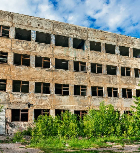 Zniszczony opuszczony duży betonowy budynek w letni dzień — Zdjęcie stockowe