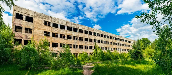 Зруйнована залишена велика бетонна будівля в літній день — стокове фото