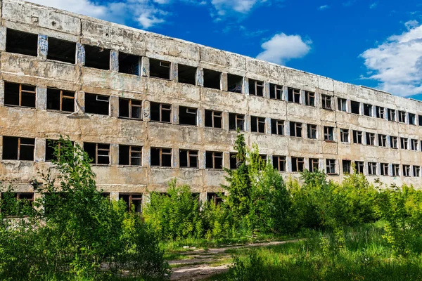 Зруйнована залишена велика бетонна будівля в літній день — стокове фото