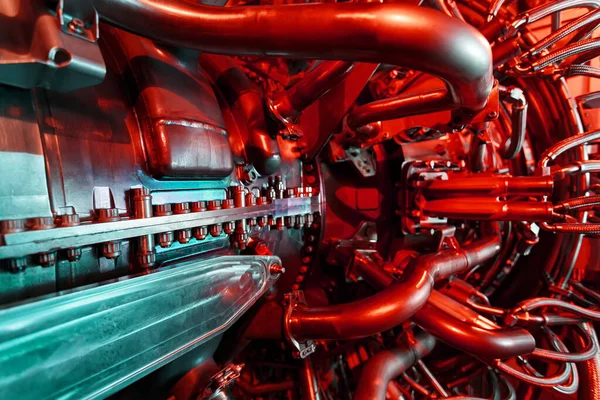 A modern gas turbine aircraft engine in a futuristic red-green light. High-tech energy of the future. Aircraft derivative, shipping and industrial turbine