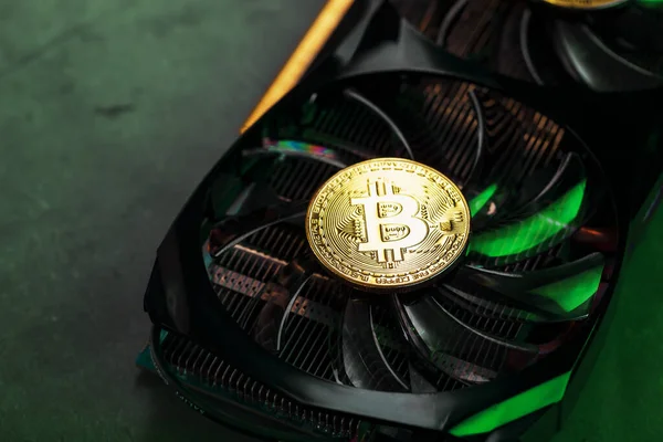 On the powerful fans of the video card there are coins of the Bitcoin cryptocurrency with a green backlight.The concept of mining and mining cryptocurrency cryptocurrency farm. Macro