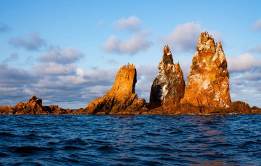 Güzel turuncu deniz yığını deniz kayalıkları mavi bulutlar gökyüzü