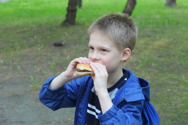 Hamburger yiyen çocuk
