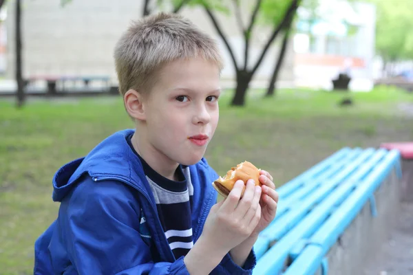 Menino comendo hambúrguer — Fotografia de Stock