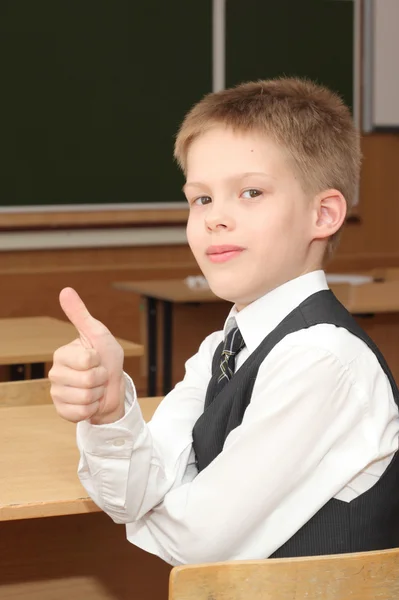 Menino na sala de aula com o polegar para cima — Fotografia de Stock