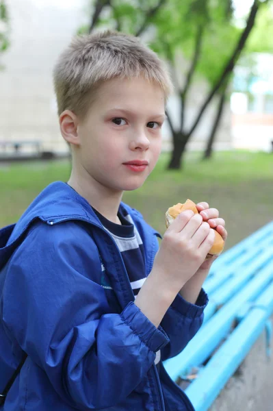 Menino comendo hambúrguer — Fotografia de Stock