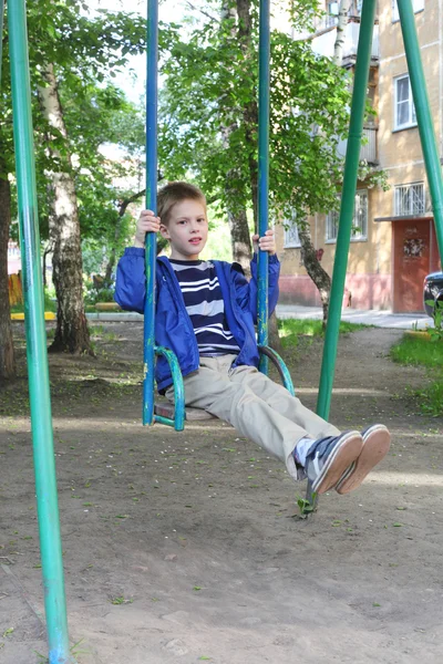 Хлопчик гойдається в парку — стокове фото