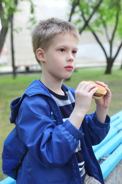 Jongen hamburger eten — Stockfoto