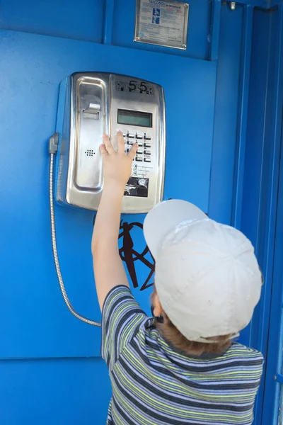 Boy speaking by the street telephone — Stock Photo, Image