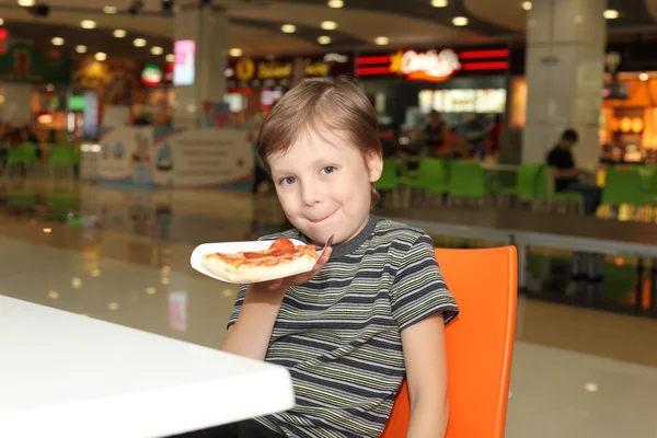 Мальчик ест пиццу — стоковое фото
