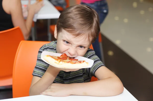 Jongen eten van pizza — Stockfoto