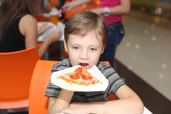 Pojken äta pizza — Stockfoto