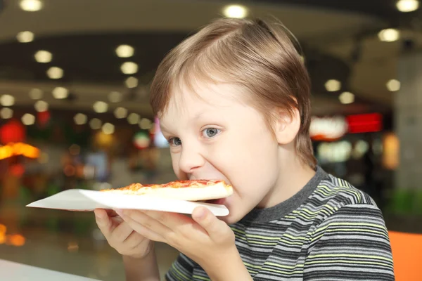 Pojken äta pizza — Stockfoto