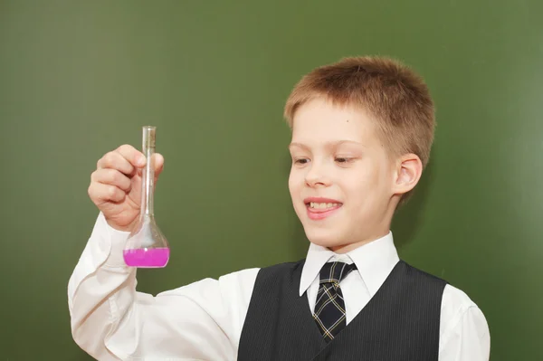 Menino com o tubo de agente químico rosa — Fotografia de Stock