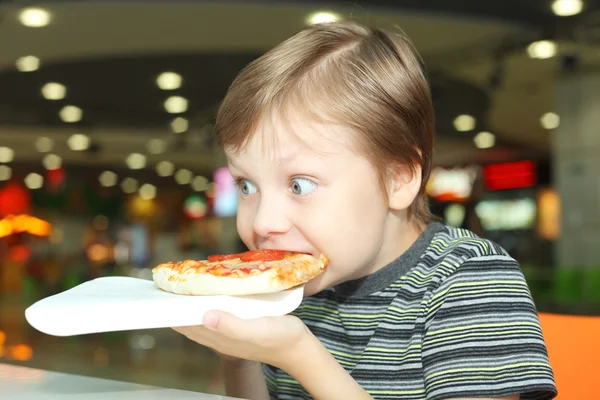 Chlapec jíst pizzu — Stock fotografie