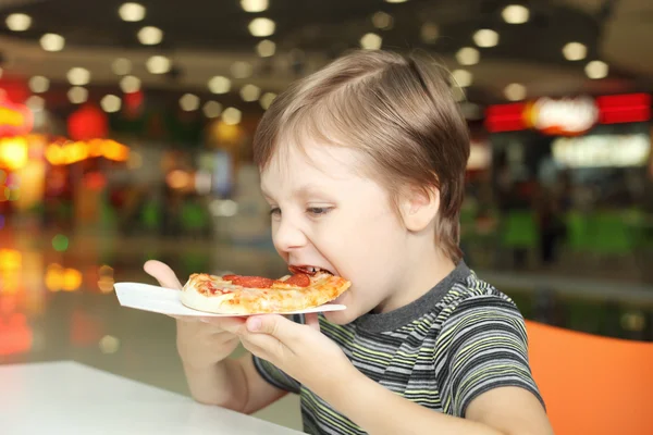 Pojken äta pizza — Stockfoto