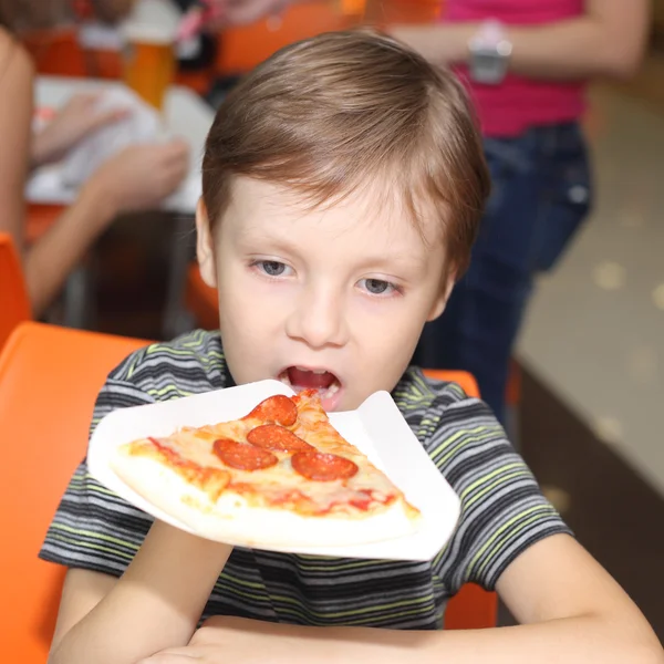 Pojken äta pizza — Stockfoto