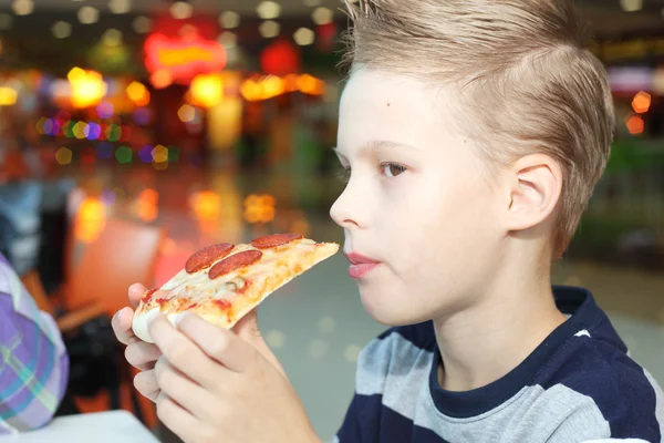 Pojken äta pizza — Stockfoto