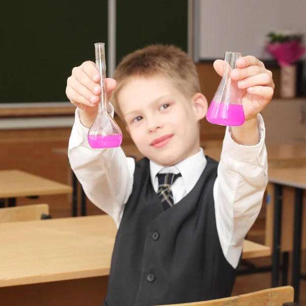 Junge mit den rosafarbenen Chemikalienröhrchen — Stockfoto