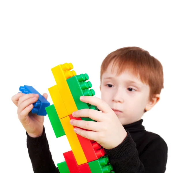 Niño haciendo pistola con ladrillos de plástico —  Fotos de Stock