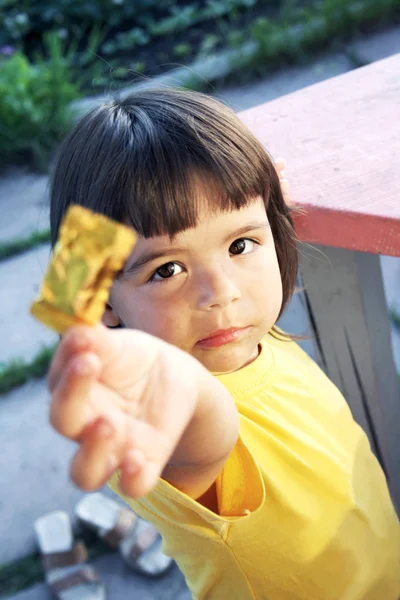 Child offering a sweet candy — Stock Photo, Image