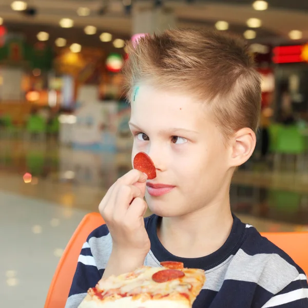 Мальчик с вкусной пиццей — стоковое фото