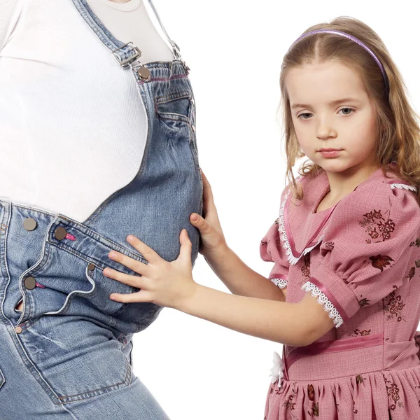 Criança segurando a barriga de sua mãe grávida — Fotografia de Stock