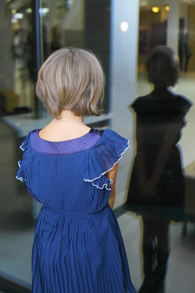 Menina olhando para a janela de reflexão — Fotografia de Stock