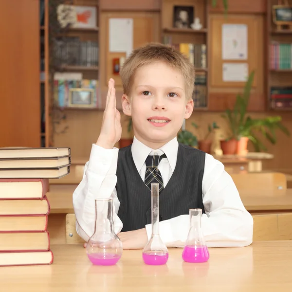 Kleiner Junge mit Büchern und Chemietuben — Stockfoto