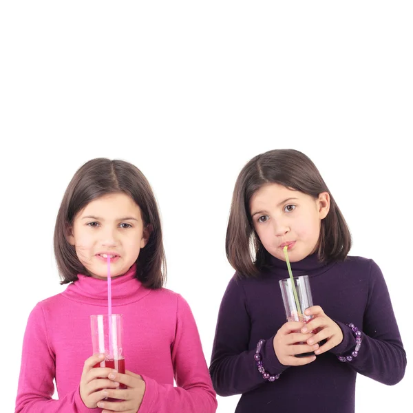 Little twin sisters drinking juice — Stock Photo, Image