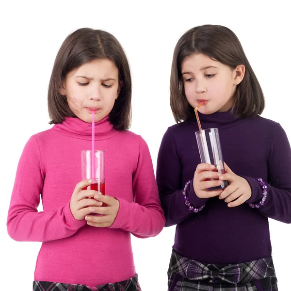 Little twin sisters drinking juice — Stock Photo, Image